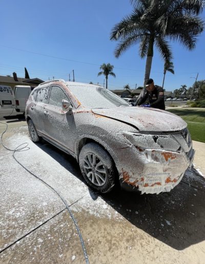 An overhead view of a car being detailed, with cleaning supplies nearby.